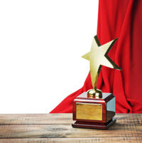 Star award wooden table and on the background of red curtain  